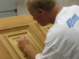 A man working on wood in a workshop.