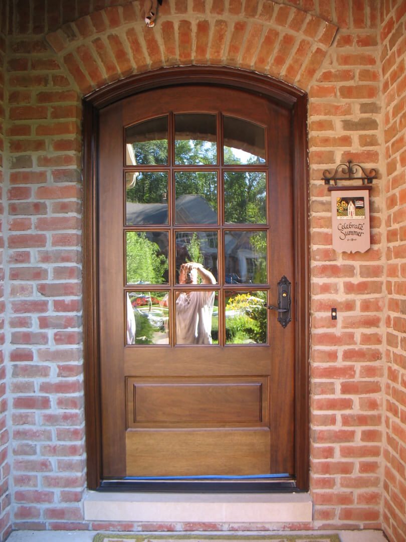 A dog is standing in the doorway of a house.