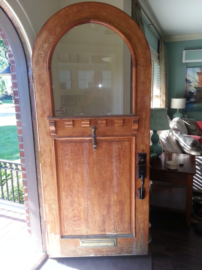 A wooden door with a glass window in it.