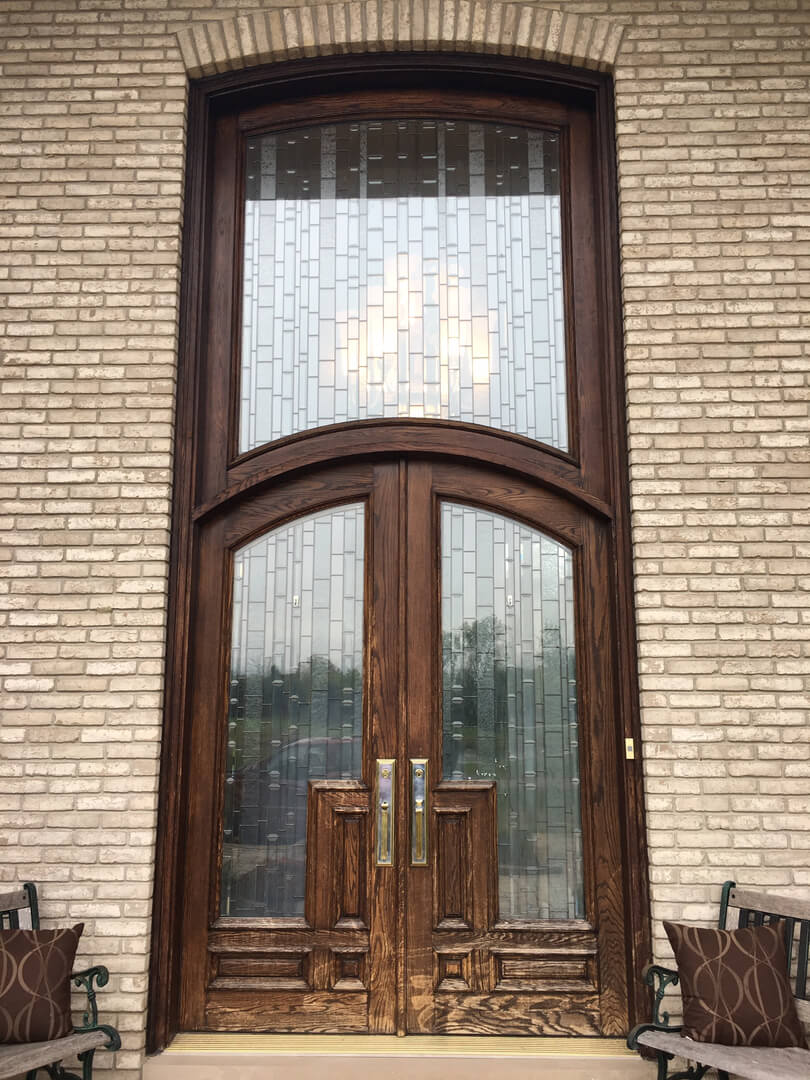 A large wooden door with two glass panels.