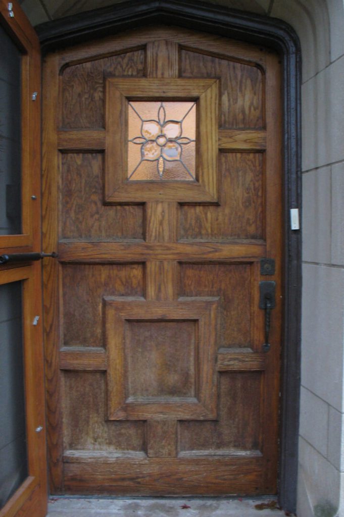 A wooden door with a stained glass window.